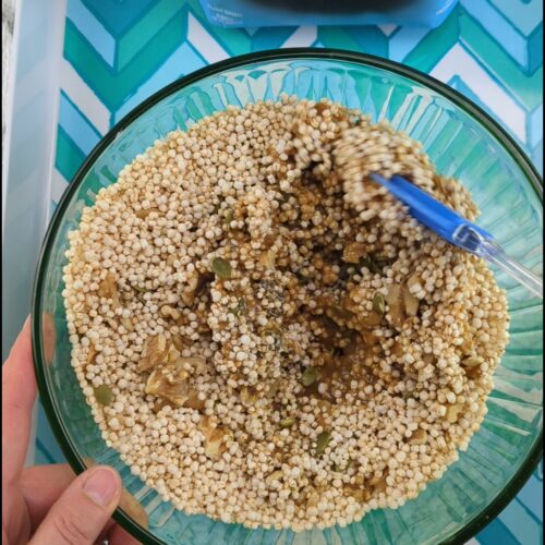 Mixing puffed quinoa being mixed in a bowl - a healthy granola alternative made with puffed quinoa, nuts, seeds, maple syrup, and almond butter.