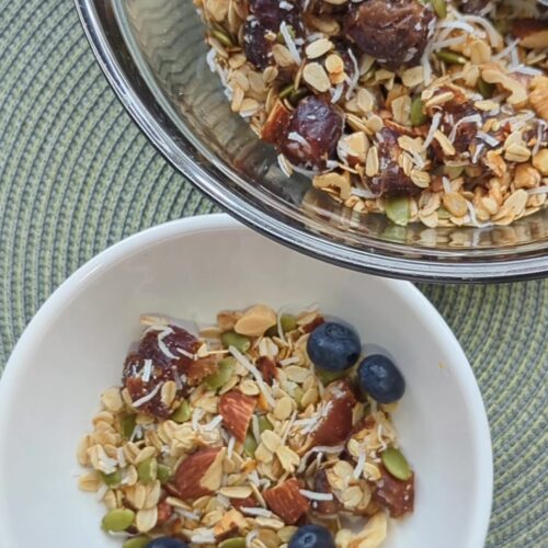 Crunchy homemade toasted muesli with oats, nuts, seeds, coconut, and dates in a bowl, perfect for a healthy make-ahead breakfast.