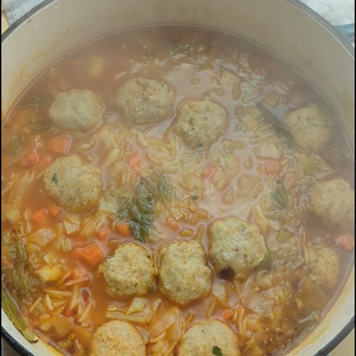 a hearty steaming bowl of cabbage soup with mini meatballs