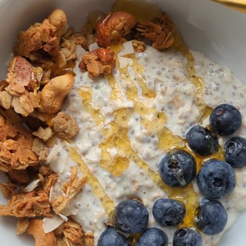 Hearty bowl of granola and oatmeal with fruit and honey